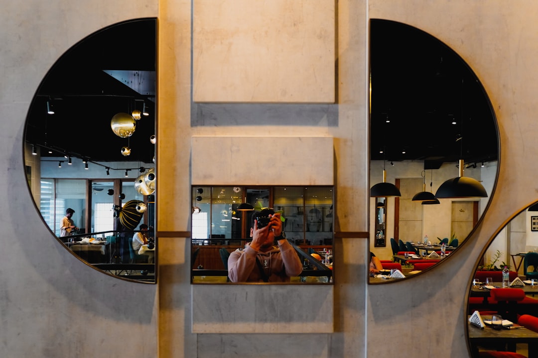 Person photographing restaurant interior with phone for Google Business Profile photos