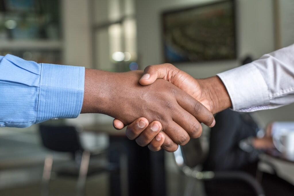 Two business owners shaking hands after closing a deal