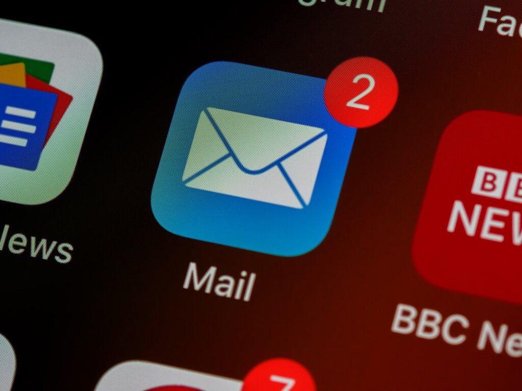 Person writing an email reply on their laptop in a bright office