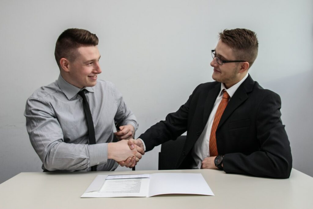 Two people shaking hands after closing a business deal