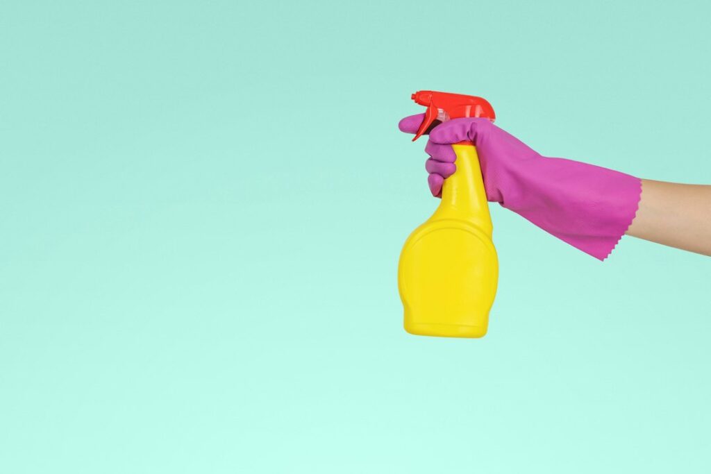 Person holding a spray bottle ready to clean a surface professionally